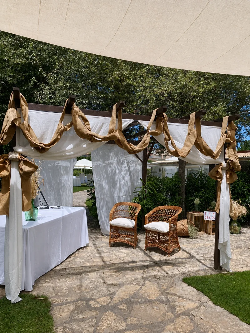 Ceremonia montada en el jardín entre los olivos, sillas puestas, plano general desde detrás de los invitados