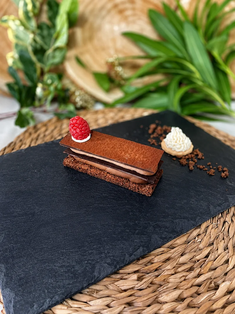 Postre de cocina propia presentado sobre pizarra negra