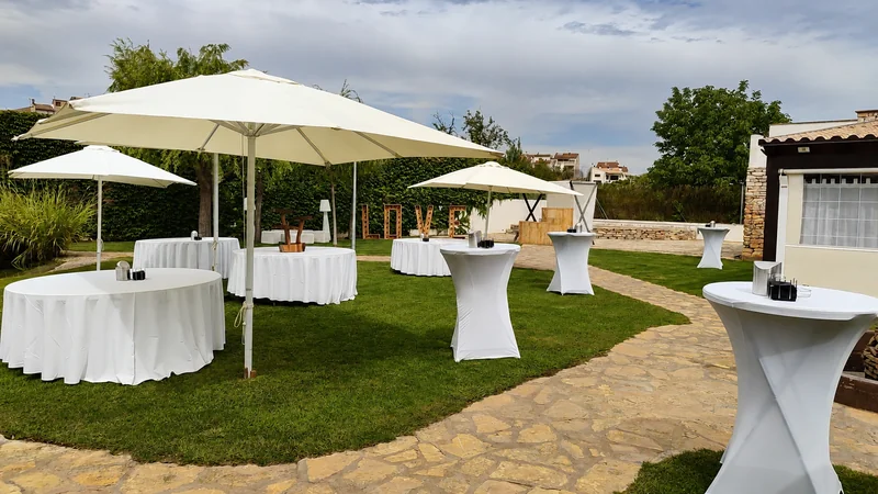 Montaje de mesas en un patio ajeno, equipo de sala terminando de colocar