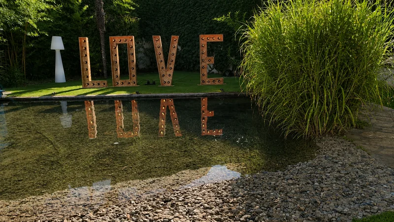 Letras LOVE junto al estanque de Finca El Tajar al atardecer